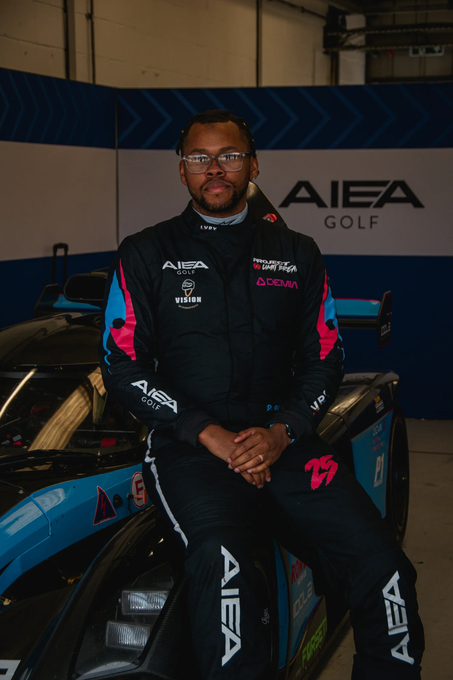 Daniel Oliver in racing suit, seated on his prototype race car